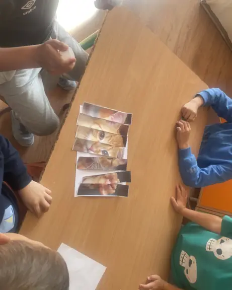 Czterech uczniów z ułożonymi puzzlami, jeszcze przed ich przyklejeniem.