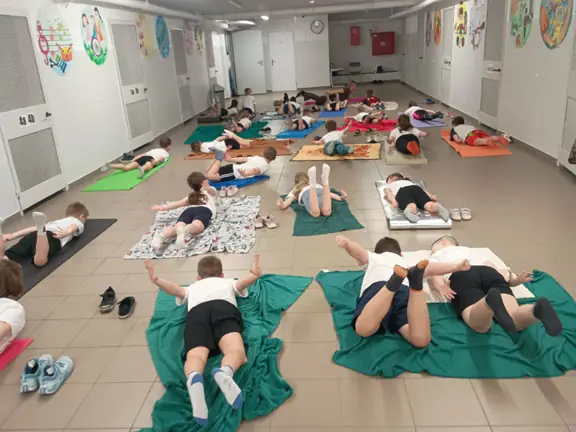 uczniowie-w-pozycji-lezacej-wykonuja-cwiczenie-z-jogi-pozycje-swiersza-jpg
