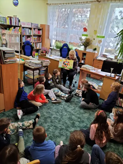 Uczniowie z kl. Id oglądają ilustrację z książki - Elmer - słoń w kratkę.