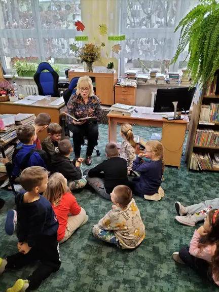Dzieci z kl. Id słuchają czytanego przez panią bibliotekarkę opowiadania o Elmerze - słoniu w kratkę.
