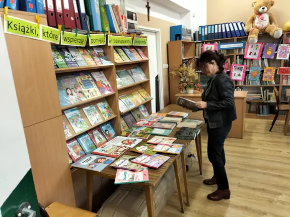 Pani Ania wychowawczyni kl. VIIIb przegląda publikację z wystawy.