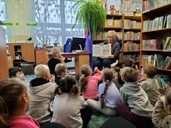 bibliotekarka-demonstruje-dzieciom-ilustracje-z-opowiesci-pani-zima--jpg