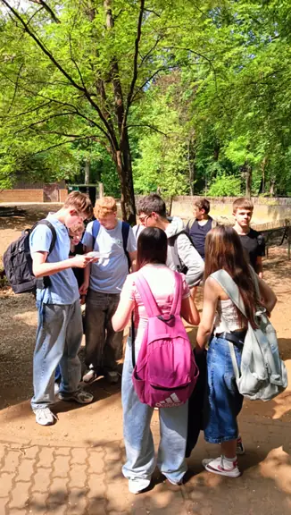 Grupa uczniów rozwiązuje zadania z gry terenowej