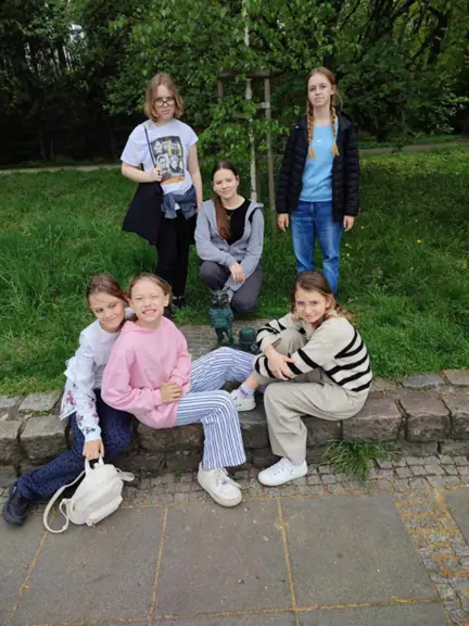 Uczennice pozują w parku obok gryfika