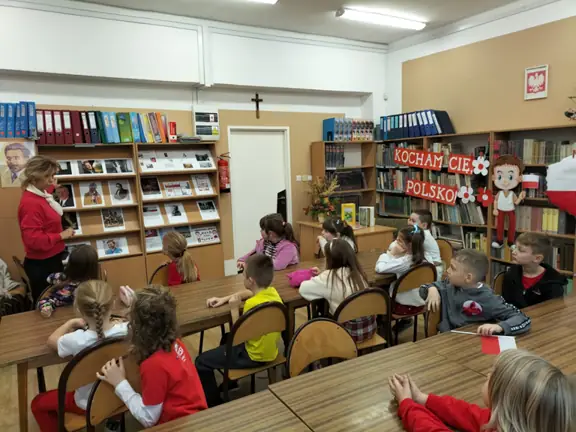 Pani bibliotekarka prezentuje uczniom kl. Id portrety znanych Polaków.