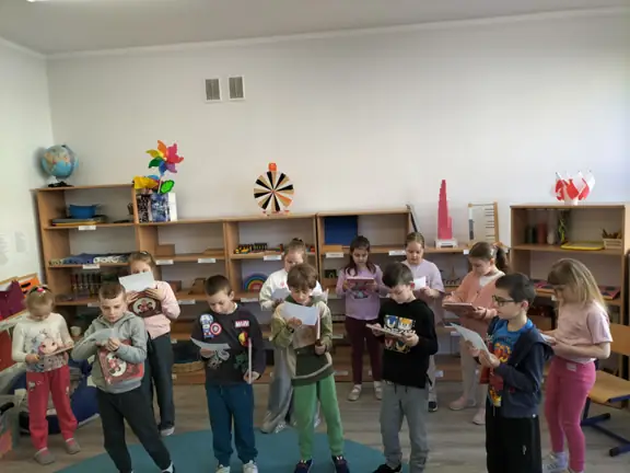 uczniowie-z-kl--1c-ogladaja-ksiazki-i-odczytuja-tekst-na-dyplomie-czytelnika--jpg