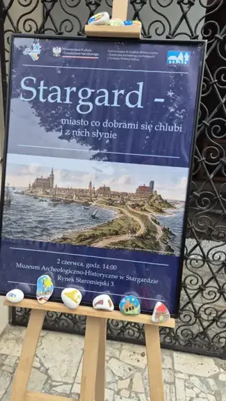 Kamyki przy plakacie promującym wystawę w muzeum