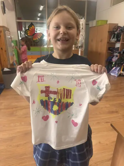 Uczennica prezentuje projekt swojej koszulki piłkarskiej