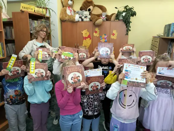 uczniowie-z-kl--1a-demonstruja-dyplomy-czytelnkia-ksiazki-i-zakladki--jpg