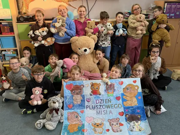 Dzieci z kl. IIIb ze swoimi misiami i pamiątkowym plakatem.