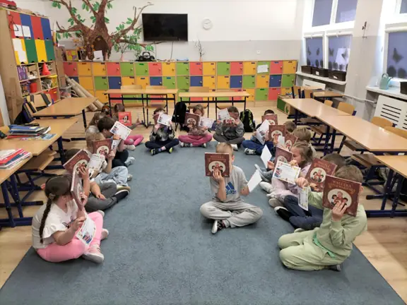 uczniowie-z-kl--1b-demonstruja-swoje-dyplomy-i-ksiazke-wnuczka-antykwariusza--jpg