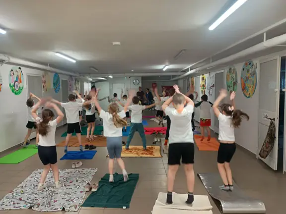 uczniowie-w-pozycji-stojacej-wykonuja-cwiczenie-na-matach-i-kocach-jpg