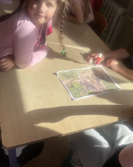 Ułożone i przyklejone przez dzieci puzzle przedstawiające rodzinę słoni.