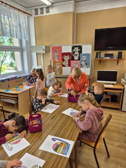 Przedszkolaki z grupy 01 kolorują tułów kota.