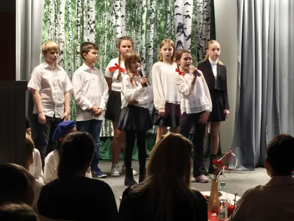 Grupka uczniów śpiewająca na scenie 