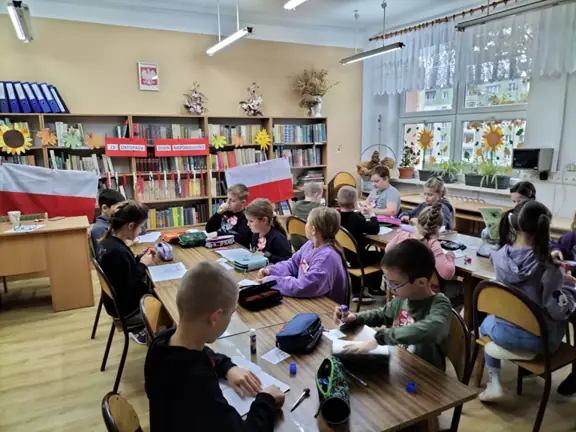 Uczniowie wklejają do zeszytu informacje o święcie.