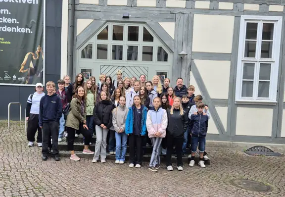 grupa wszystkich uczestników przed budynkiem muzeum