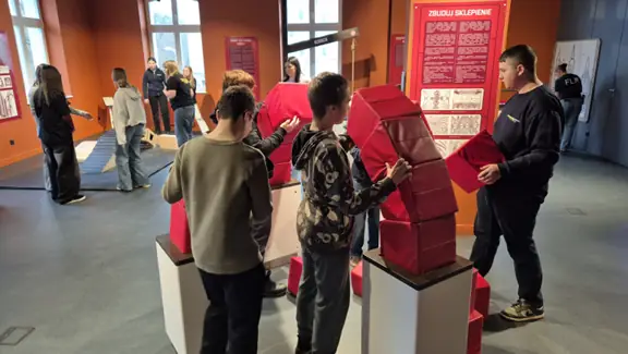 Uczniowie wspólnie budują sklepienie z cegiełek z gąbki