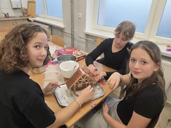 Uczennice ozdabiają domek z piernika