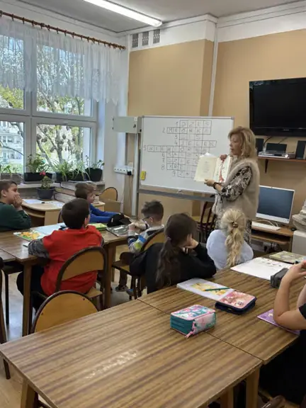 Pani bibliotekarka prezentuje uczniom kl. IIc tomik wierszy Jana Brzechwy.
