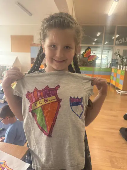 Uczennica prezentuje projekt swojej koszulki piłkarskiej