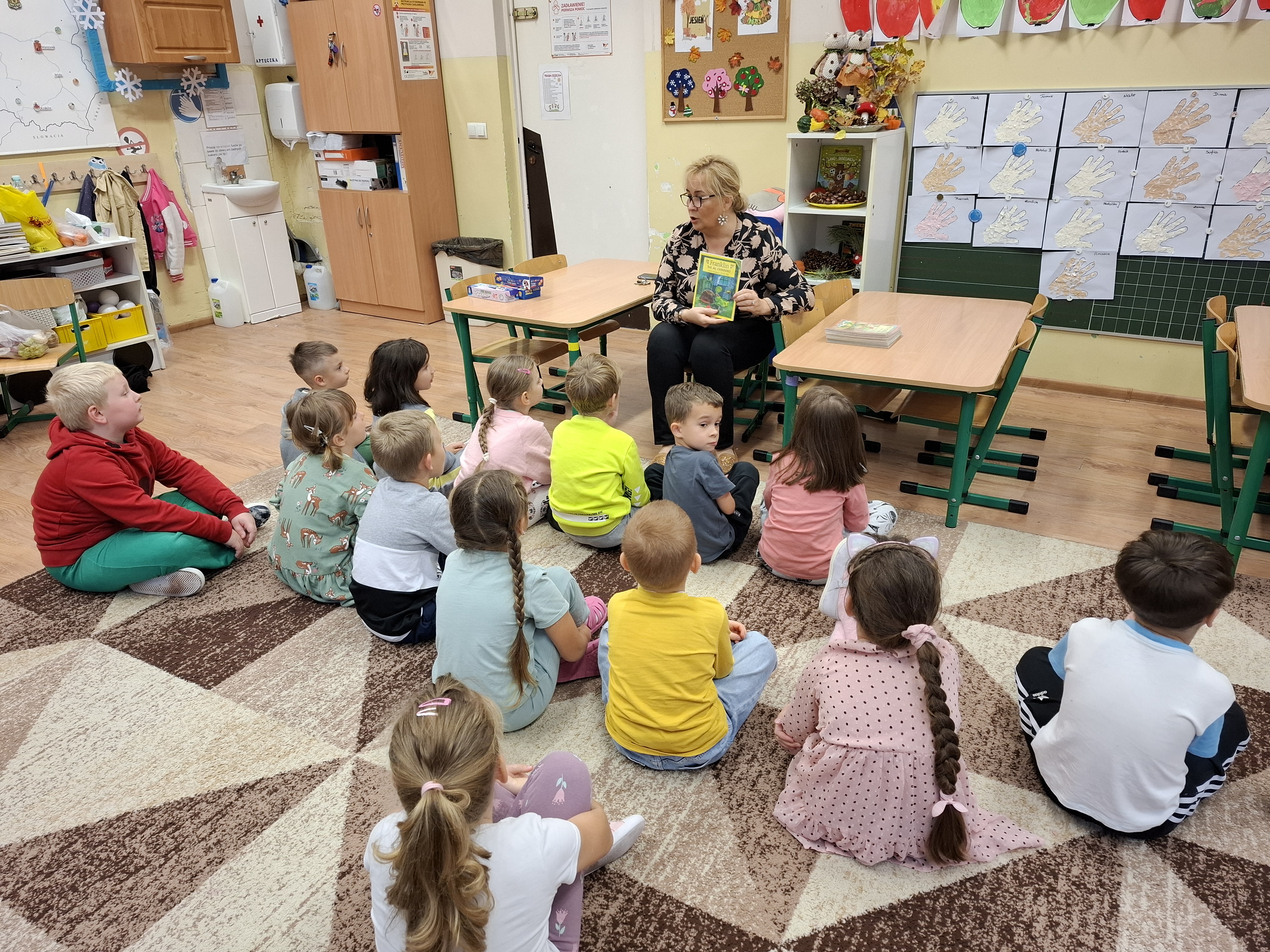 Pani bibliotekarka rozmawia z dziećmi podczas spotkania - Czytanie na dywanie