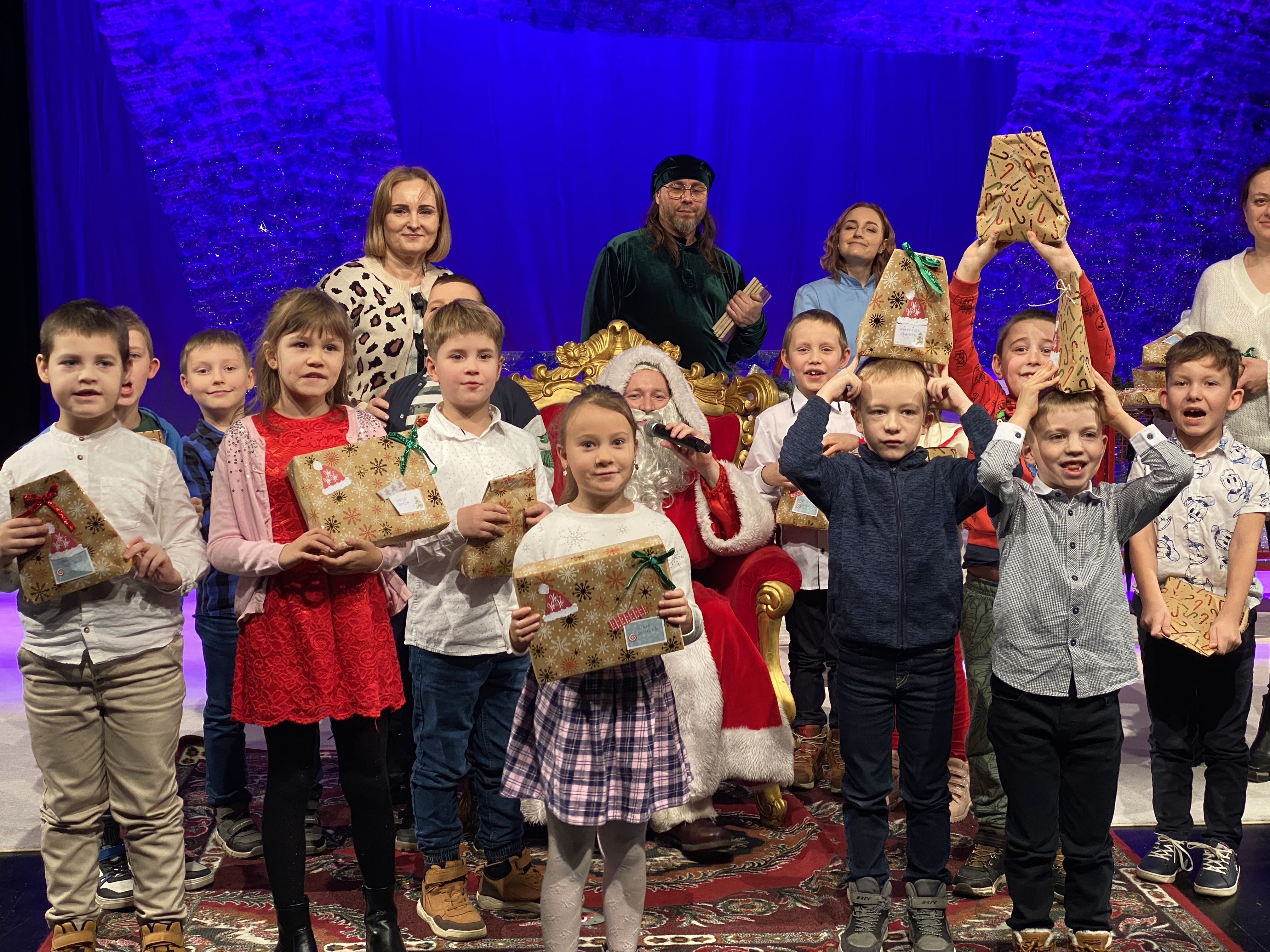 Dzieci z klasy pierwszej a pozują z Mikołajem na scenie Teatru Lalek Pleciuga