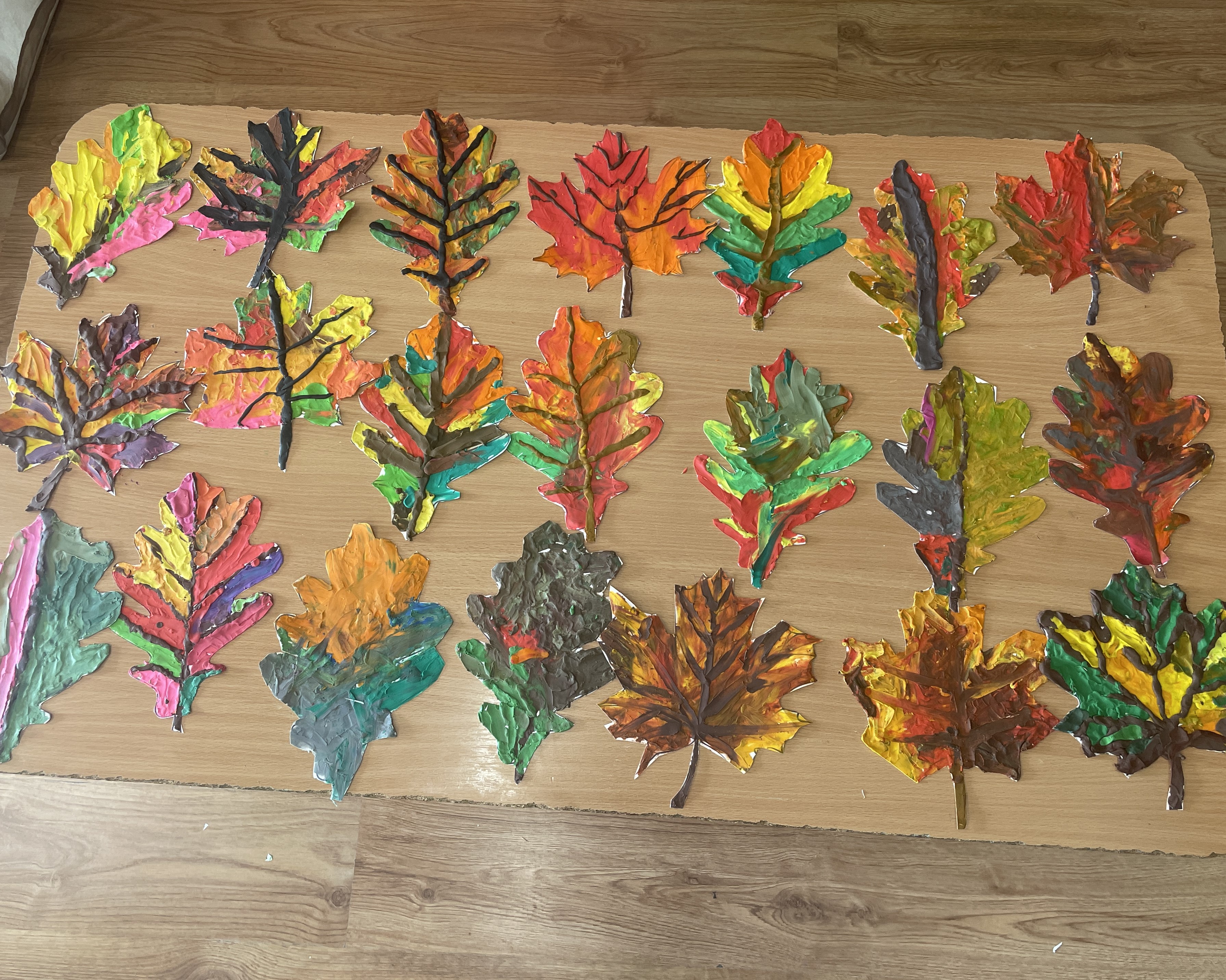 Zdjęcie przedstawiające wykonane i wycięte przez dzieci liście w jesiennych barwach