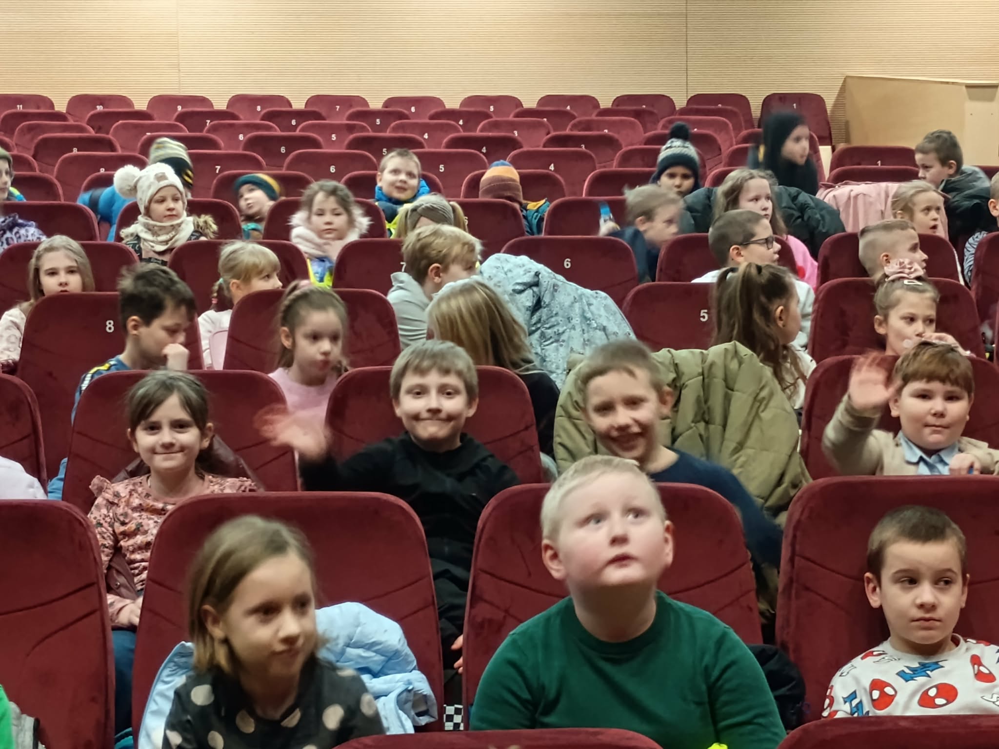 Uczniowie siedzą w kinie w oczekiwaniu na spektakl
