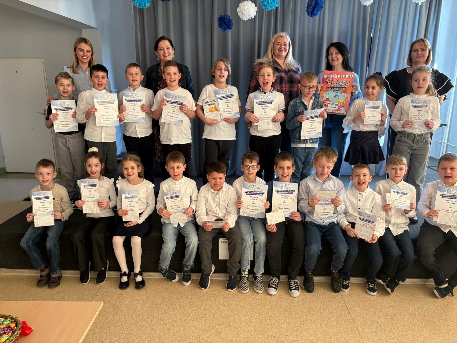 Uczniowie klas 1-3 na scenie po wręczeniu dyplomów za udział w Ogólnopolskim Konkursie Matematycznym Fenek