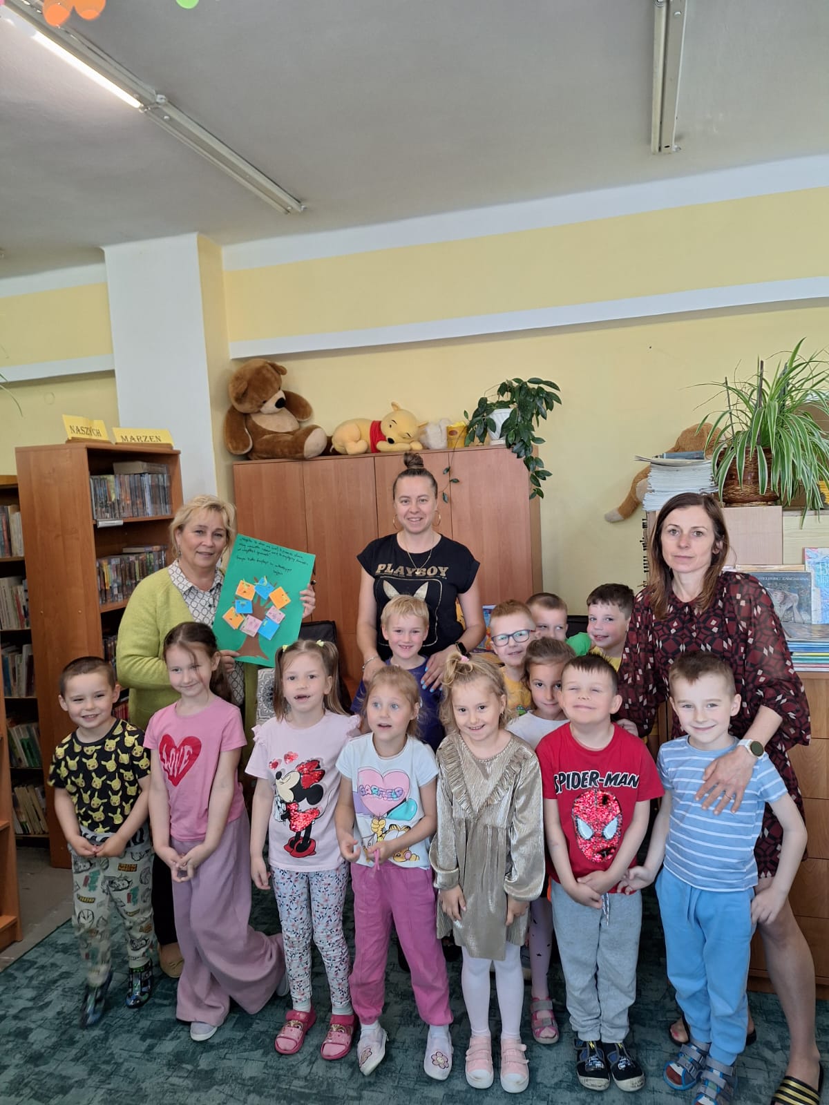 Pamiątkowe zdjęcie przedszkolaków z wychowawczyniami i bibliotekarką